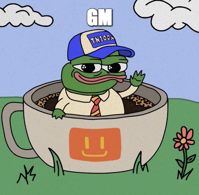 A cartoon illustration of a Pepe the Frog character wearing a 'TN100x' cap and tie, sitting in a coffee cup labeled with a smiley face logo, with the text 'GM' above.