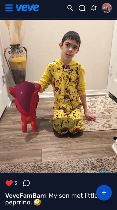 A boy in yellow Pikachu pajamas kneels on a wooden floor next to a small red figurine, in a Veve app post captioned 'VeveFamBam My son met little pepprino.'
