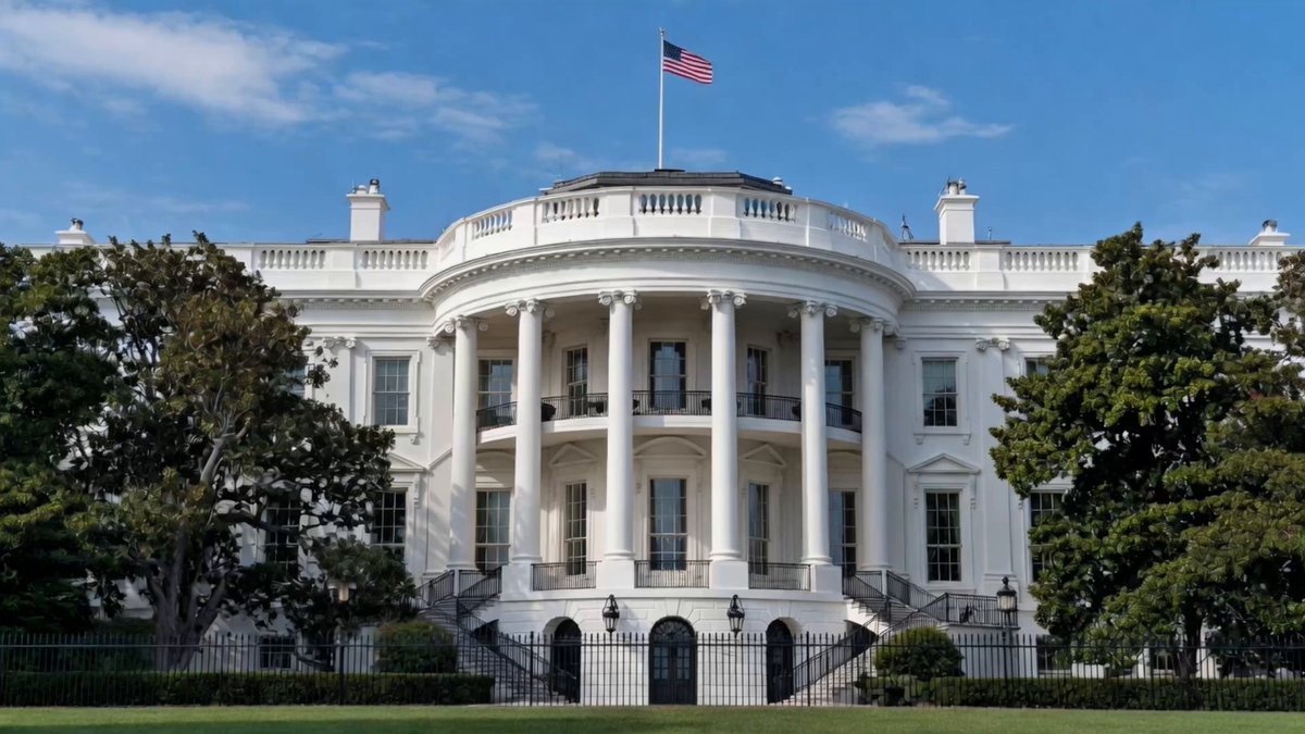 The image features a large white building with columns, which appears to be the White House. The building has an American flag flying atop its roof. In front of the building, there are trees that add greenery to the scene. The image also contains text that reads "401K GOES XRP Trump has signed an order opening 401(k) retirement plans to crypto assets. This places XRP in front of millions of American retirement portfolios and opens the door to a massive wave of institutional capital.", which suggests that the White House is being used as a platform for promoting cryptocurrency like XRP among the public.