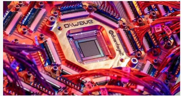 Close-up macro photo of a D-Wave Advantage quantum computing chip, with the 'D-Wave' and 'Advantage' branding visible on the chip surrounded by red wiring.