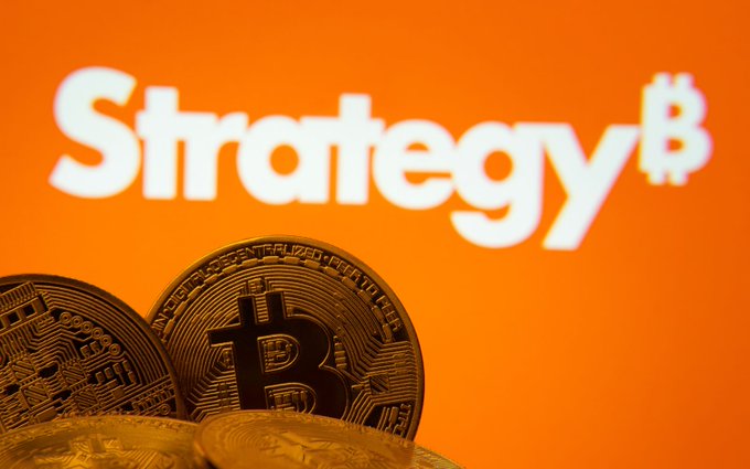 Gold Bitcoin coins displayed in front of an orange background featuring the white "Strategy₿" logo.