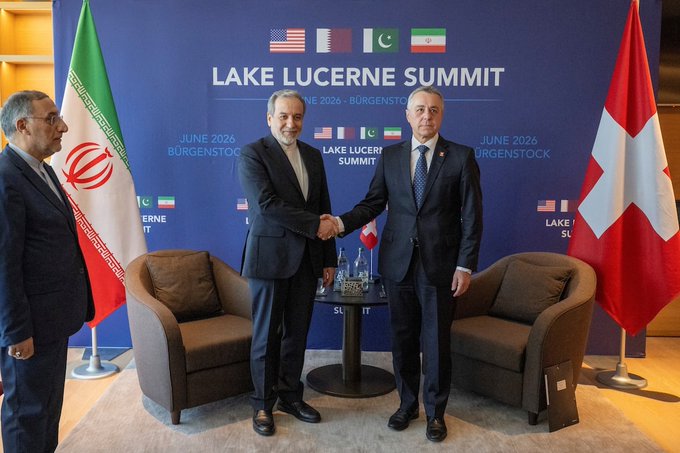 The image shows three men shaking hands, with a backdrop featuring flags from different countries. The text "US-Iran talks begin today in Switzerland" suggests that this meeting could be related to international relations or diplomatic discussions between the United States and Iran. The presence of the words "Bullish for Bitcoin and crypto" indicates that there might be an ongoing discussion about cryptocurrency, possibly related to the global economy or financial markets.