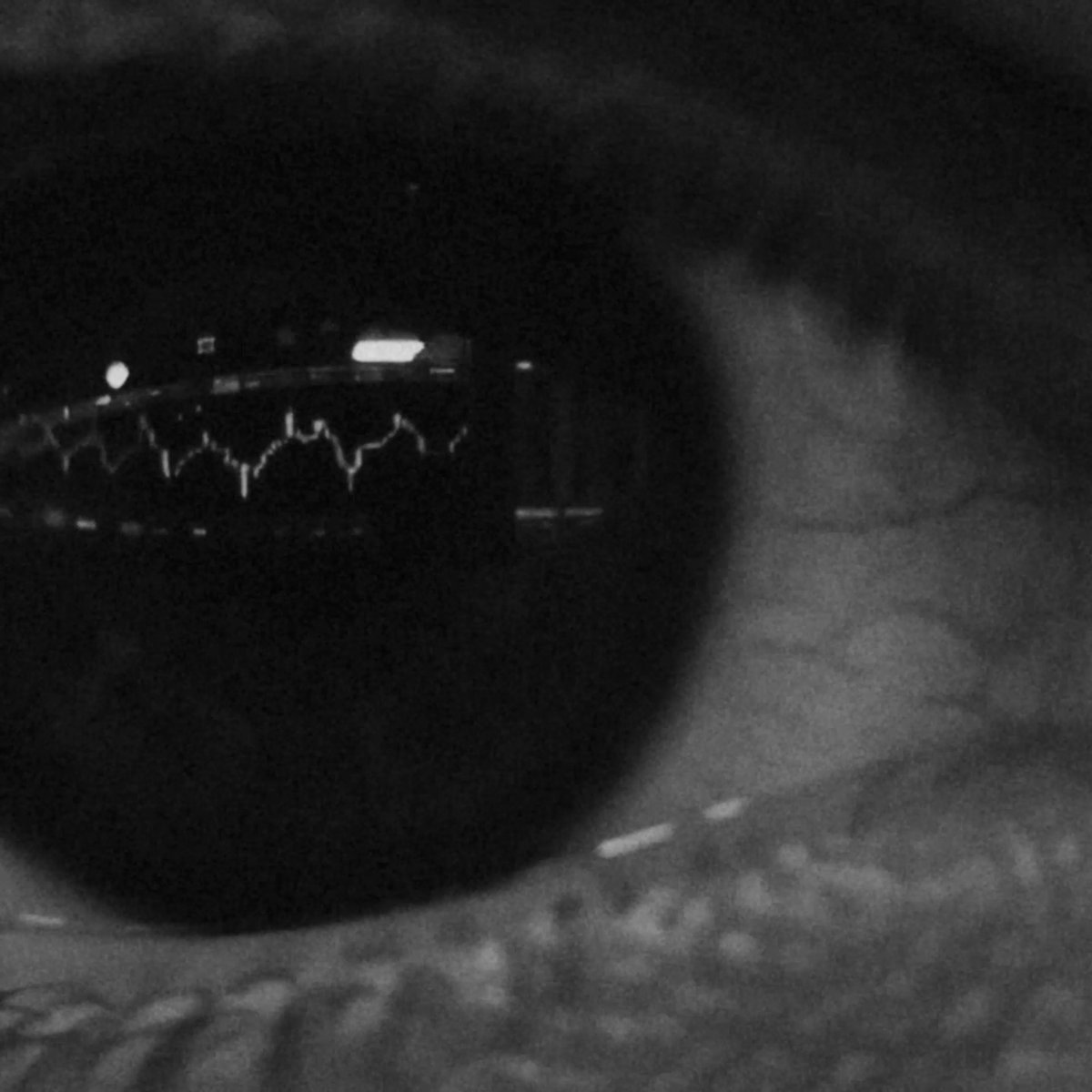 The black-and-white thermal or night-vision image shows a dark, rounded device with a small illuminated display screen showing a waveform graph and indicator lights, likely a smartwatch or wearable tracker, with a person's hand and wrist visible in the background.

This image appears to represent the concept of an intelligent wearable device, linking to OKX's message about combining human strategy with intelligent automation for smarter trading.
