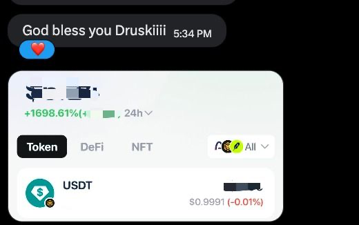 A screenshot of a chat message reading 'God bless you Druskiiii' alongside a price alert showing a 1698.61% increase for a token paired against USDT.