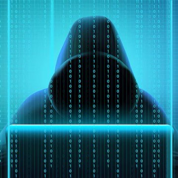 A mysterious silhouette of a hooded figure types on a glowing laptop, surrounded by cascading blue streams of binary code, evoking a stereotypical hacker.