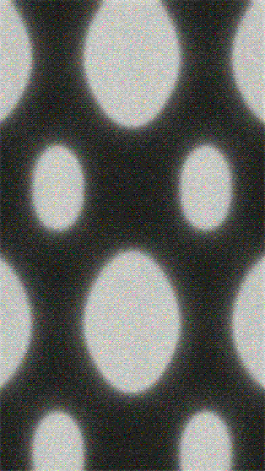 A blurred black and white image featuring a pattern of large, out-of-focus white circles on a dark background.