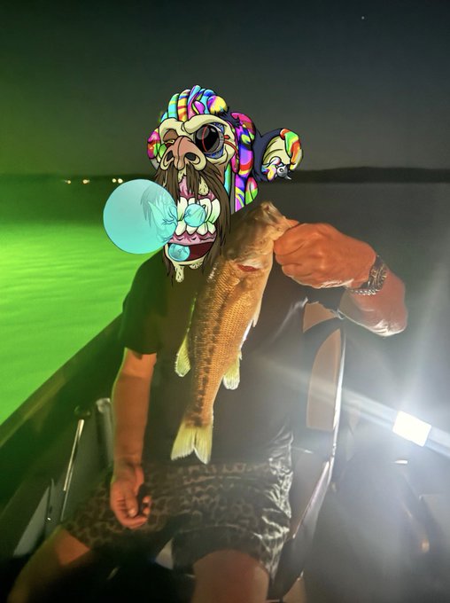 A person on a boat at night holds up a freshly caught fish, their face covered by a colorful cartoon snorkel mask filter, with a glowing green and dark sky in the background — a perfect "GM Happy Mutant Monday!" vibe of strange and stylish fun.