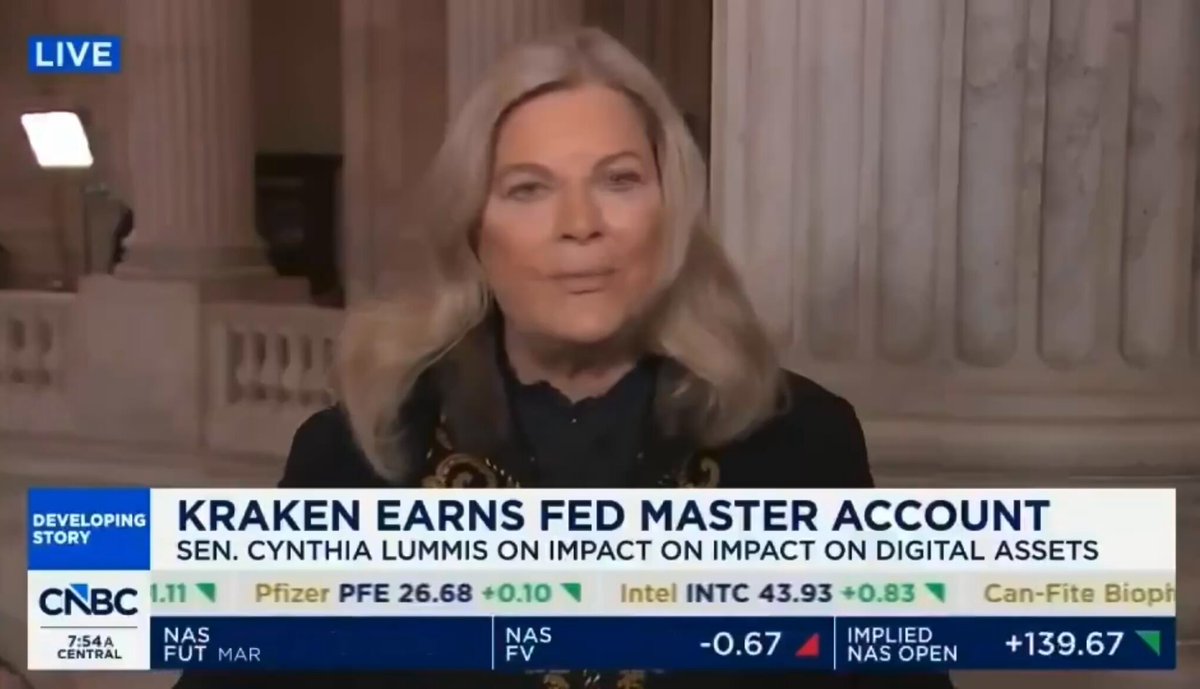 The image features a woman with blonde hair, wearing a black jacket, sitting behind a desk while talking about Bitcoin on a news program. The text on the screen reads "BULLISH: Senator Lummis says all banks will soon be able to offer Bitcoin. TRILLIONS could flow into crypto." This suggests that there is an ongoing discussion or event related to Bitcoin and its potential impact on financial institutions, with the possibility of significant wealth accumulation for those who invest in it.