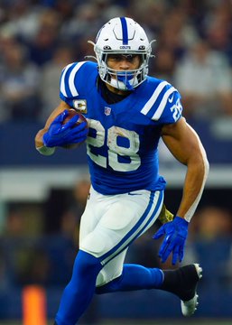 An Indianapolis Colts player wearing jersey number 28—identified as Jonathan Taylor by the accompanying post—runs with the ball tucked in his arm during a game. The image visually supports the post's reference to Taylor, highlighting the running back whose touchdown scoring odds are being wagered on.