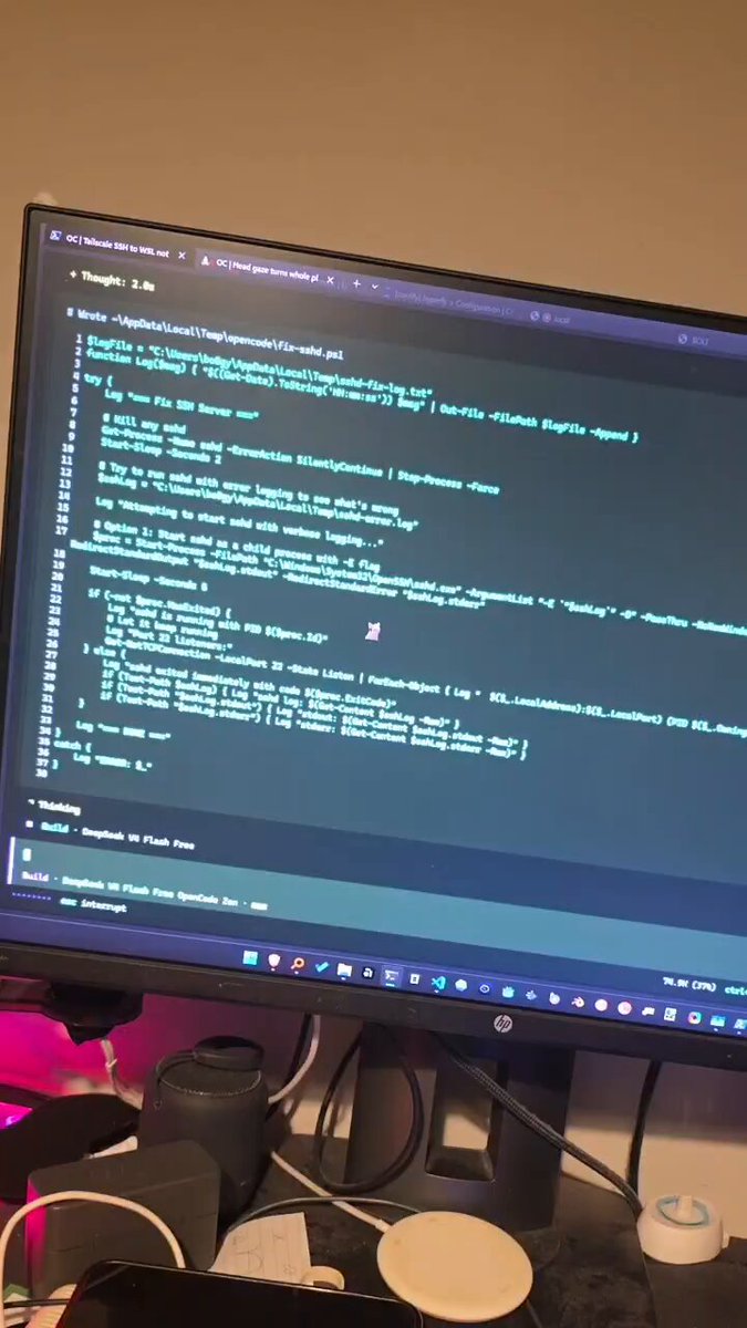 The image shows an open computer screen displaying code, possibly from a programming language like Python or JavaScript. The code appears to be complex, with multiple lines of text and symbols. The background of the image features a gray wall, which contrasts with the vibrant colors on the screen. There is also a cup placed near the monitor, adding to the overall scene.
