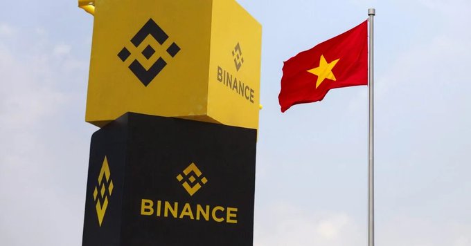 Binance cryptocurrency exchange signage alongside the Vietnamese flag, suggesting operations in Vietnam.