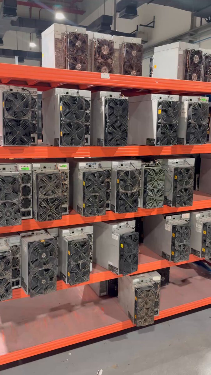 The image shows a large number of computer servers, specifically cooling fans or air conditioners, lined up on shelves within an indoor space. These cooling units are designed for use with Bitcoin mining equipment, which requires efficient temperature control to maintain optimal performance. The presence of multiple cooling units suggests that the environment is likely to be a high-traffic area where the hardware needs to function effectively and efficiently in order to support Bitcoin mining operations.
