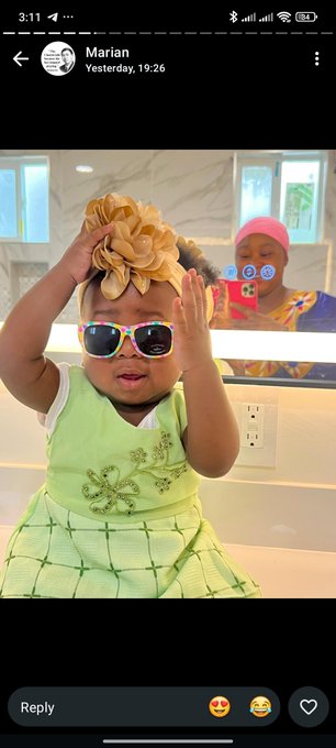 A screenshot of a Snapchat message from 'Marian' showing a baby in a green dress, colorful sunglasses, and a large beige hair bow, posing in a mirror.