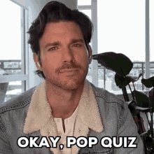 The image features a man wearing a denim jacket, with his face partially visible as he looks directly at the camera. The caption below him reads "Okay, pop quiz," which seems to be a reference to a pop culture event or trend. The text in the caption also mentions that there are three things that have become more decentralized on Tezos over the past three years.