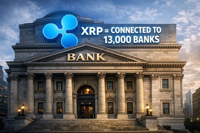 The image features a large, old-fashioned building with columns and a sign that reads "THE SECRET IS OUT: BANKS ARE BUYING XRP! Get this Tohoku Bank just adopted Ripple tech!". The text on the sign is in blue, which stands out against the beige background of the building. The image also includes a photo of a city skyline with buildings and streetlights, providing context to the scene.
