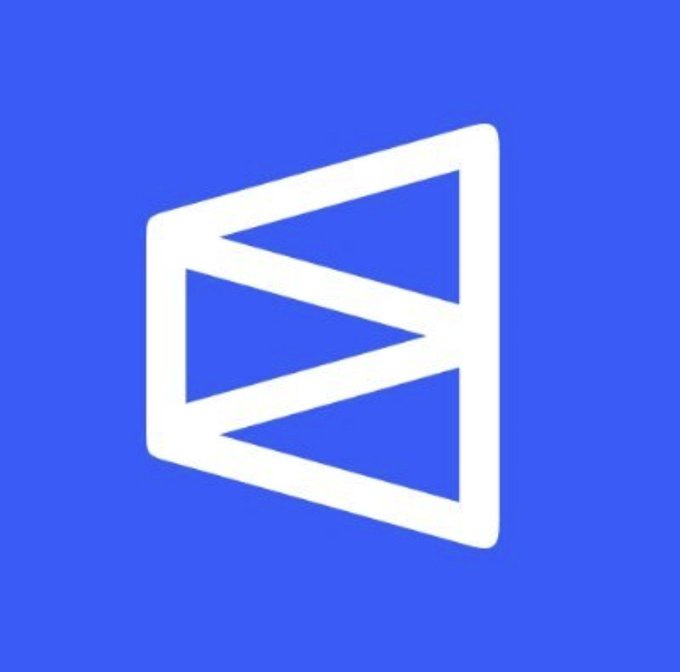 A white geometric "M" or flag-like logo on a blue background, symbolizing Polymarket, the prediction platform referenced in the post about its token launch not happening this year.