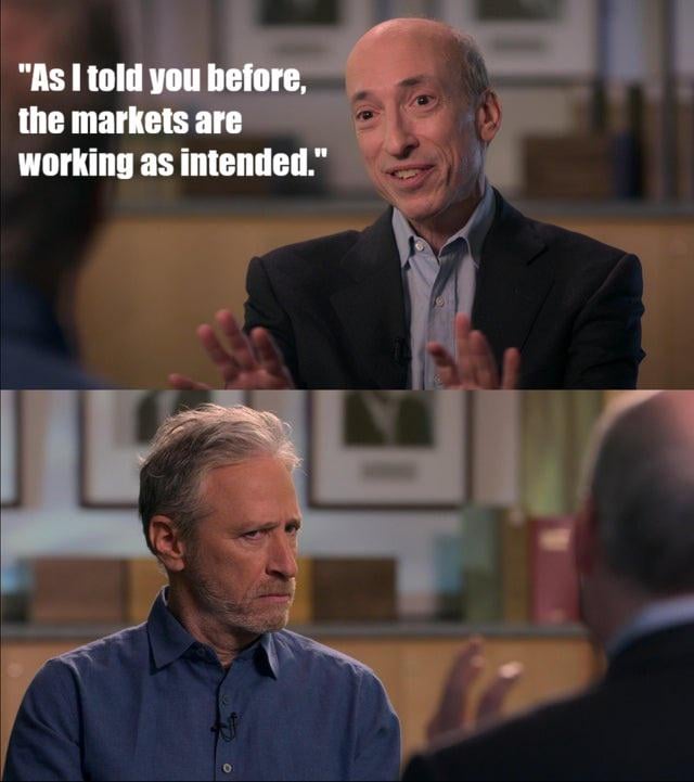 A meme-style two-panel image from an interview showing Gary Gensler smiling with the caption 'As I told you before, the markets are working as intended,' while the interviewer (Bill Maher) looks unamused.