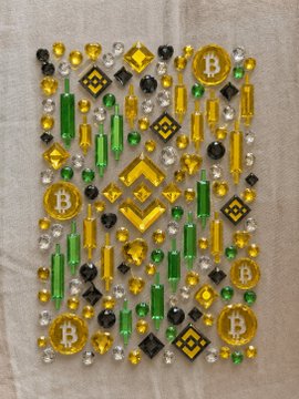 A clear/transparent laptop case adorned with colorful gems, yellow Bitcoin "₿" coins, and Binance logos, visually representing crypto wealth as a tangible, "manifested" object. The Bitcoin and Binance branding tie the image directly to the idea of turning digital crypto success into a real, valuable possession.