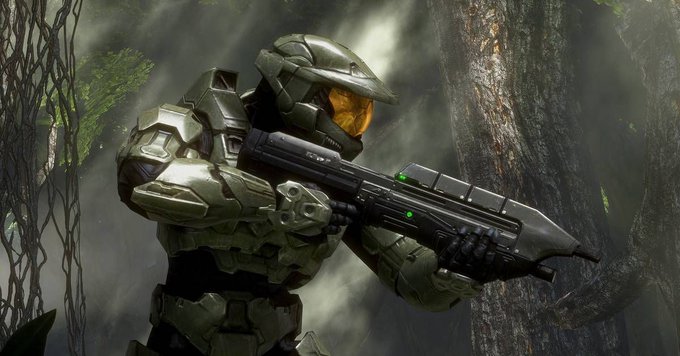 Master Chief, the iconic protagonist from the Halo franchise, stands ready with his assault rifle amidst a lush, misty jungle environment, evoking the atmospheric world of the original Halo game that is now playable in web browsers.