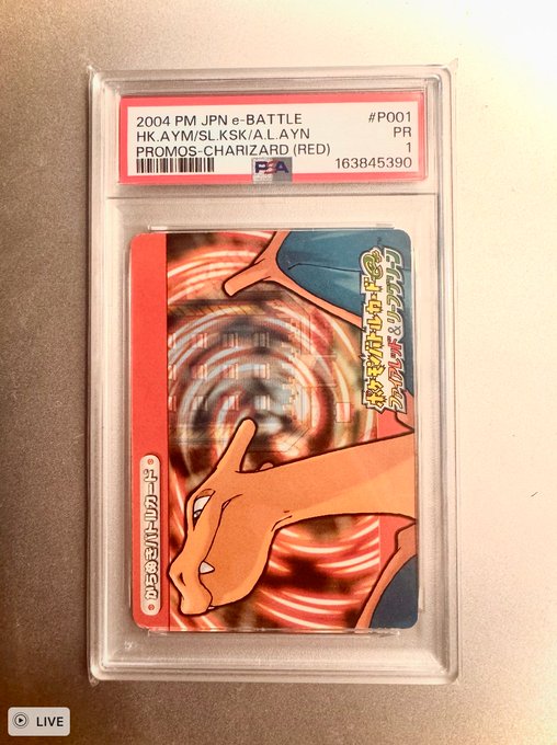 A PSA-graded Japanese Pokémon card in a protective case, labeled '2004 PM JPN e-BATTLE HK.AYM/SL.KSK/A.LAYN PROMOS-CHARIZARD (RED) #P001', featuring Charizard artwork.