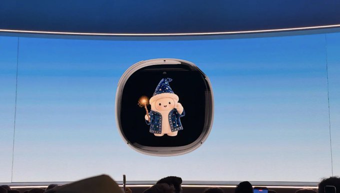 A cute cartoon character with a wizard hat and starry cape floating inside a rounded square display on a curved screen against a blue background.