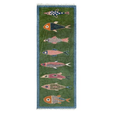 A decorative green textile or tapestry featuring seven stylized, colorful embroidered fish in horizontal rows, with the bottom-most fish appearing larger.