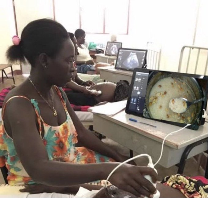 Photo of a woman seated at a desk using an ultrasound machine in what appears to be a training setting, with other women and equipment visible in the background.