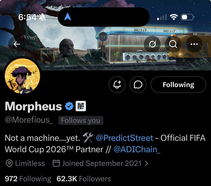 Twitter profile of Morpheus (@Morefious_) displayed on mobile, showing 62.3K followers, a bio stating "Not a machine....yet" with affiliations to @PredictStreet (FIFA World Cup 2026™ Partner) and @ADIChain_, and a banner featuring a digital matrix-style scene. The accompanying post highlights his generosity in sending people to World Cup experiences, aligning with his FIFA partnership.