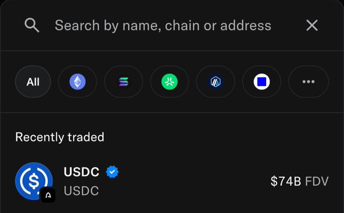 A dark-themed search interface with a bar reading 'Search by name, chain or address', showing recently traded assets including 'USDC' with a $74B FDV.