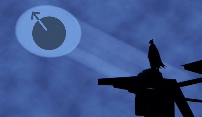 A silhouette of a figure in a cape stands on a structure at dusk, gazing at a large glowing circular object with an arrow symbol in the blue sky.