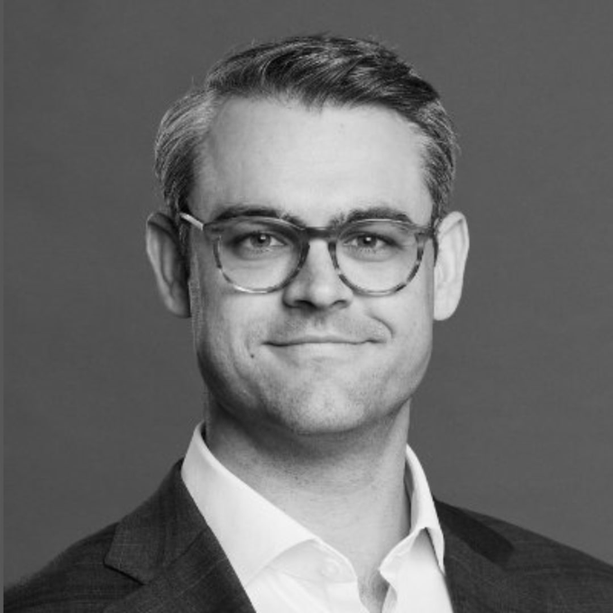 A black-and-white portrait shows Hunter Horsley, CEO of Bitwise, wearing clear-framed glasses, a checkered blazer, and a white collared shirt, smiling softly against a plain gray background. The image accompanies an update about his commentary on how cryptocurrency unites people from diverse backgrounds around the shared goal of building a better future.