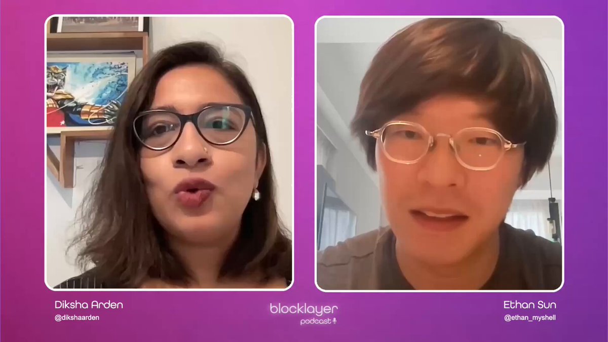 The image shows two people sitting next to each other with their faces displayed against a purple background. The person on the left has long hair and is wearing glasses, while the person on the right has short hair and is also wearing glasses. They are both looking at the camera, appearing engaged in conversation or discussion.
