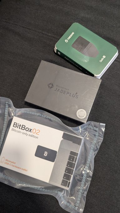 The image shows a Trezor Model T (in green packaging) and a BitBox02 Bitcoin-only edition (Minimalist USB-C hardware wallet) alongside a Jade Plus by Blockstream, all hardware wallets arranged on a dark surface. These items support the post about setting up a multi-vendor multisig setup using devices from different manufacturers (Trezor, Shift Crypto's BitBox02, and Blockstream's Jade Plus) to enhance security.