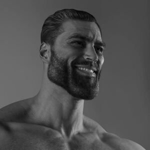 A black and white close-up portrait of a shirtless, bearded man smiling.