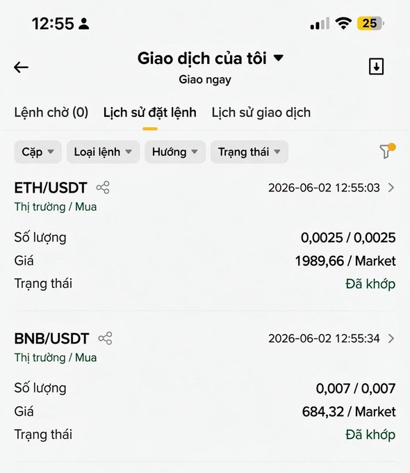 The image shows a phone screen with a list of cryptocurrency names displayed in both English and Vietnamese. The text includes descriptions such as "ETH/USDT", "BNB/USDT", and "0.07/0.77". The phone's time is also visible, showing that the photo was taken at 12:55.
