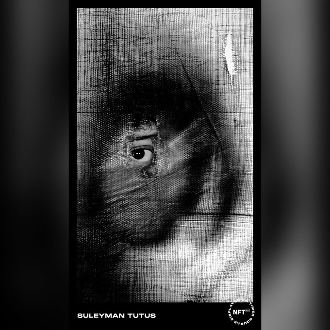 A black and white NFT artwork titled 'SULEYMAN TUTUS' from the Open Spirit NFT collection, depicting a haunting face peering through a textured veil.