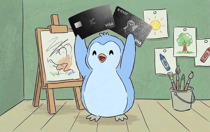 A cheerful blue cartoon penguin happily holds up two Visa credit cards—one branded "KAST" with a black pattern design and another plain black card—standing in an art studio next to an easel and a bucket of paintbrushes. The image ties to the post by playfully promoting joining the KAST community, visually representing the excitement of receiving a KAST Visa card as part of the experience.