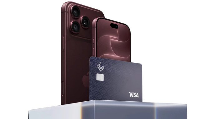 A dark red/maroon iPhone with a Visa credit card featuring Apple branding, displayed on a clear pedestal.