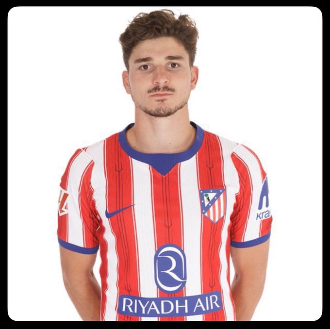 A young man with curly brown hair and a goatee poses in an Atlético Madrid red and white striped jersey featuring the "Riyadh Air" sponsor logo and Nike swoosh, with a partial "Kra..." visible on the sleeve. The image appears to be an official team portrait, though its connection to the post about mixing camp activities with NFTs and crypto trading on Robinhood is unclear.