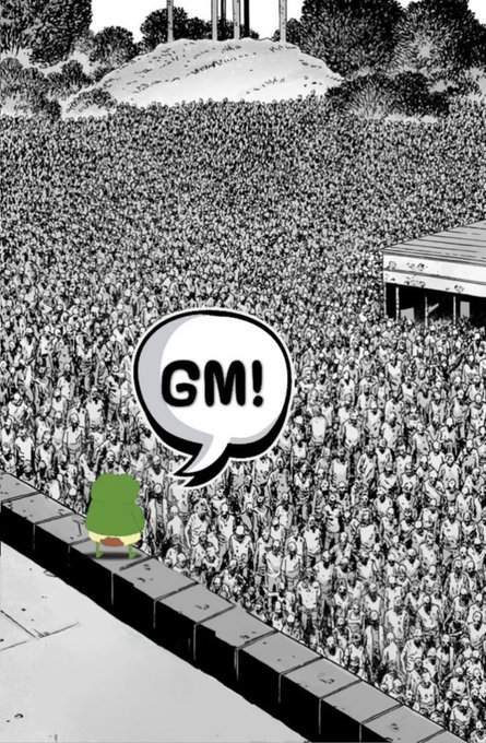 A small frog character stands on a stage facing a massive stadium crowd, with a speech bubble reading "GM!" echoing the post's cheerful "gm to everyone happy sunday." greeting to the sea of fans.