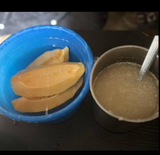 A blue bowl of cantaloupe melon slices sits next to a cup of blended beverage or soup on a dark table, offering a modest, simple meal. The image reflects the poster's current state of financial stress and minimal resources while seeking crypto opportunities with $ANSEM and @TermMaxFi.