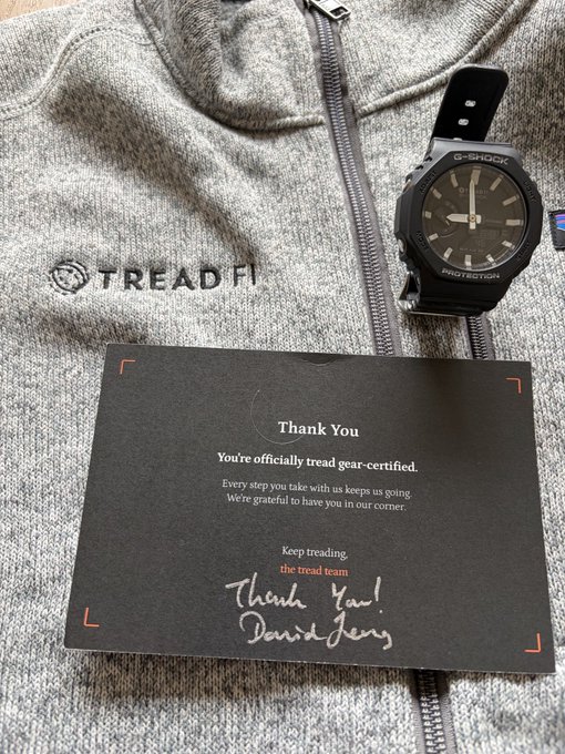 A TreadFi branded thank you card reading 'You're officially tread gear-certified' with a handwritten signature from David Levy, displayed on a gray zip-up hoodie next to a G-Shock watch.