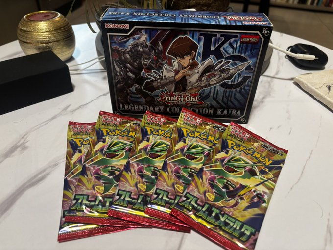 A Konami Yu-Gi-Oh! GX Legendary Collection KAIRA box set displayed behind five Japanese Pokémon TCG booster packs on a white surface.
