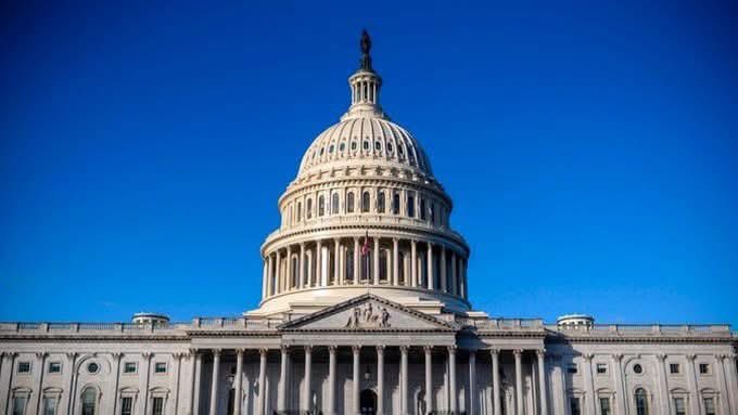 A low-angle shot of the United States Capitol building's white dome against a clear blue sky.