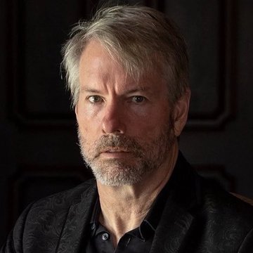 A middle-aged man with gray hair and a beard, wearing a dark patterned blazer over a black shirt, gazes intently at the camera against a dark background. The image likely represents Michael Saylor, referenced in the accompanying post discussing his sale of 1,637 BTC and an upcoming live broadcast.