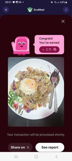 The image shows an EcoMeal app confirmation screen featuring a pink mascot congratulating the user on earning 2.11 B3TR tokens, alongside a photo of a plated meal containing rice and vegetables. This visual aligns with the post's message about earning 2.11 #B3TR through EcoMeal on VeBetterDAO, celebrating sustainable eating habits.