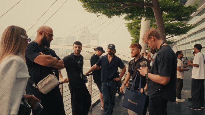 A group of attendees gathers at TOKEN2049 Singapore, with one holding a "SharkyAI" branded bag, capturing the networking and connections made at the crypto conference before the next stop in Dubai.
