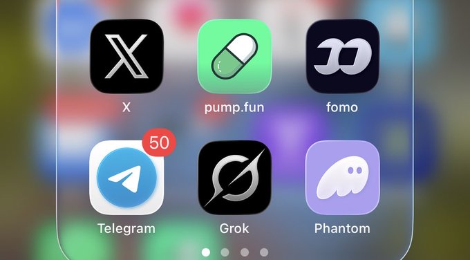 A close-up of a smartphone home screen displaying app icons for X, pump.fun, fomo, Telegram (with 50 notifications), Grok, and Phantom against a blurred background.
