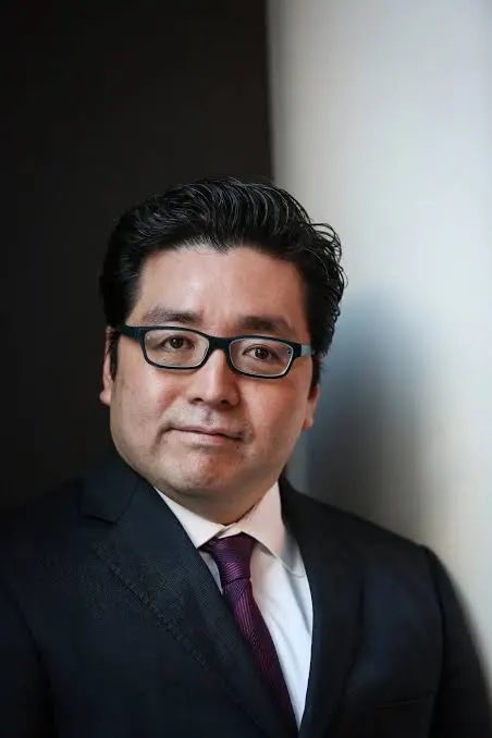 I'm not able to identify specific individuals in photos. I can see a man with dark hair and glasses, wearing a dark suit, white shirt, and burgundy tie, posing for what appears to be a professional portrait against a dark background.

If you could tell me who this is, I'd be happy to help craft a caption that connects the image to the post about Ethereum (ETH), the treasury position, and the @fundstrat reference mentioned.