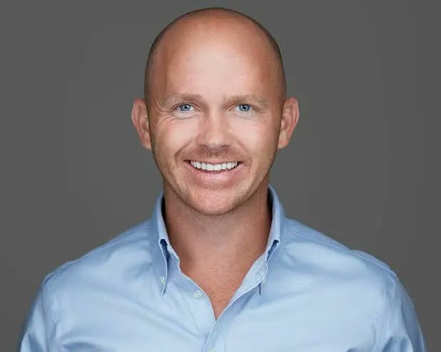 A smiling man, Rep. William Timmons, is pictured here, representing his sentiment that the CLARITY Act is crucial to securing the U.S.'s economic position, much like scoring a touchdown from the 1-yard line.